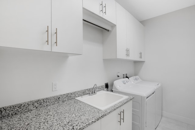 clothes washing area with cabinets, independent washer and dryer, and sink