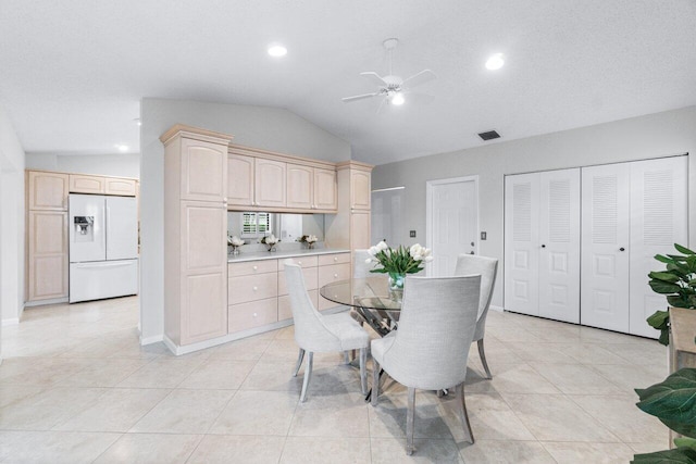 dining room with ceiling fan, light tile patterned floors, and vaulted ceiling