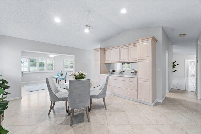 dining space featuring ceiling fan, light tile patterned flooring, a textured ceiling, and vaulted ceiling