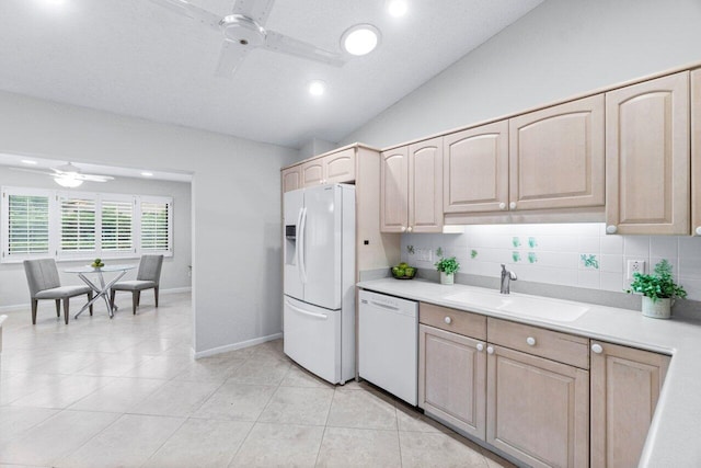 kitchen featuring ceiling fan, backsplash, lofted ceiling, white appliances, and light brown cabinetry