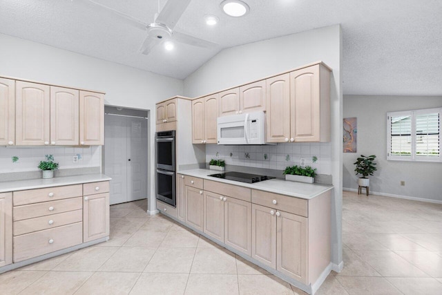 kitchen with double oven, black electric stovetop, a textured ceiling, and lofted ceiling