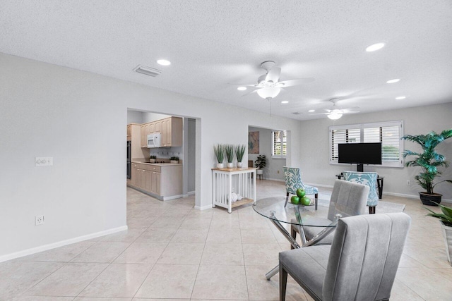 dining room featuring light tile patterned floors, a textured ceiling, and ceiling fan