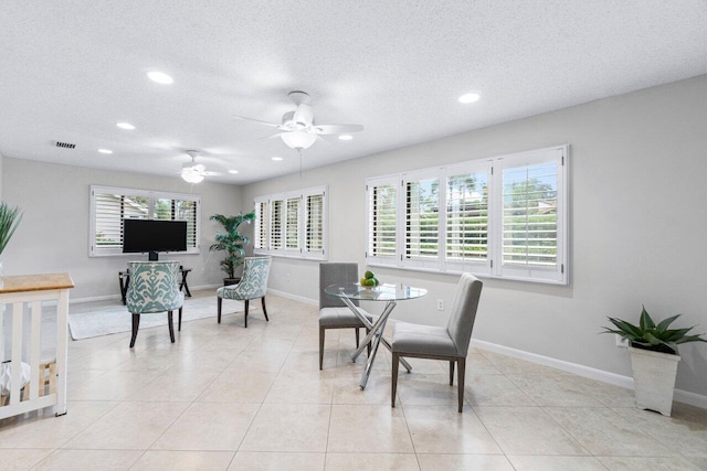 dining room featuring ceiling fan, light tile patterned floors, and a textured ceiling