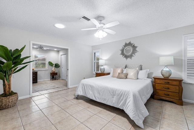 tiled bedroom featuring a textured ceiling and ceiling fan