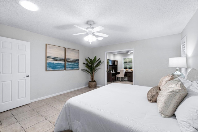 tiled bedroom with a textured ceiling and ceiling fan