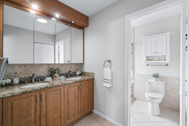 bathroom featuring toilet, vanity, a textured ceiling, and tile patterned floors