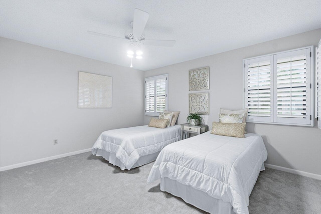 carpeted bedroom with ceiling fan and a textured ceiling