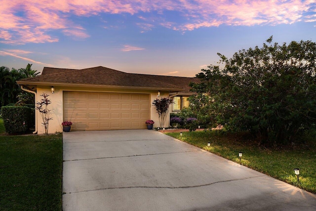 view of front of property with a garage and a lawn