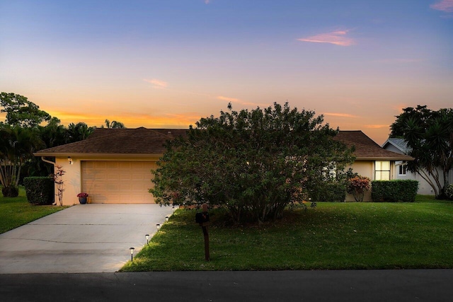 view of front facade with a yard and a garage