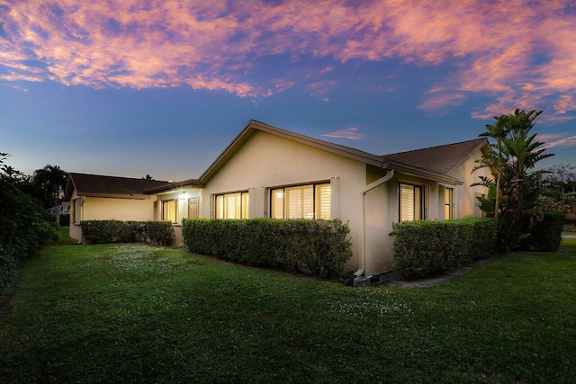 property exterior at dusk with a yard