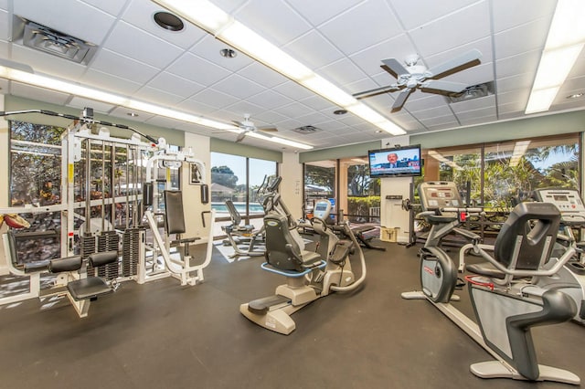 gym with ceiling fan and a drop ceiling