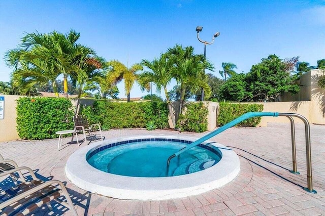 view of swimming pool featuring an in ground hot tub