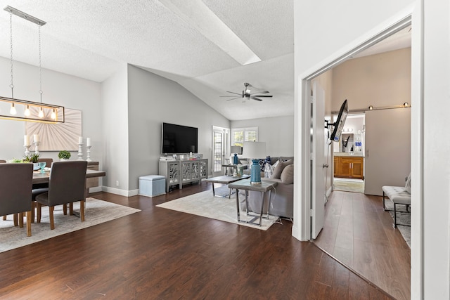 living room featuring a textured ceiling, vaulted ceiling, and dark wood-type flooring