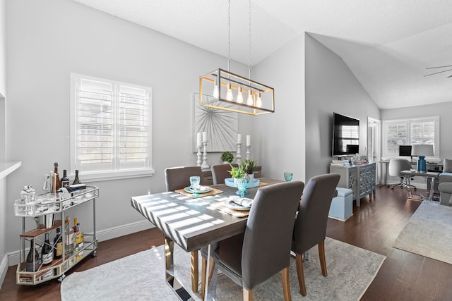 dining area featuring plenty of natural light, dark hardwood / wood-style floors, ceiling fan, and vaulted ceiling