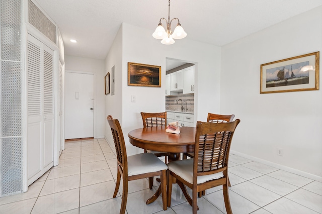 tiled dining space featuring sink and a chandelier