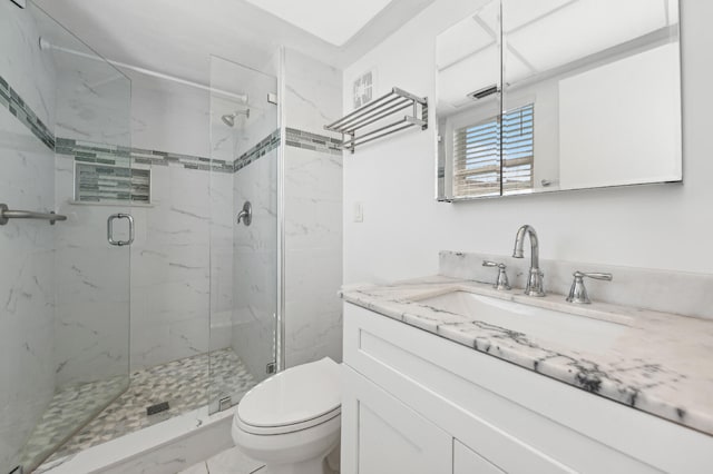 bathroom featuring an enclosed shower, vanity, and toilet