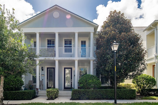 neoclassical home featuring a balcony