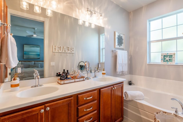 bathroom with a tub to relax in, ceiling fan, and vanity