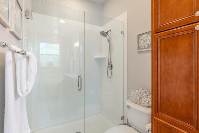 bathroom with toilet and a shower with shower door