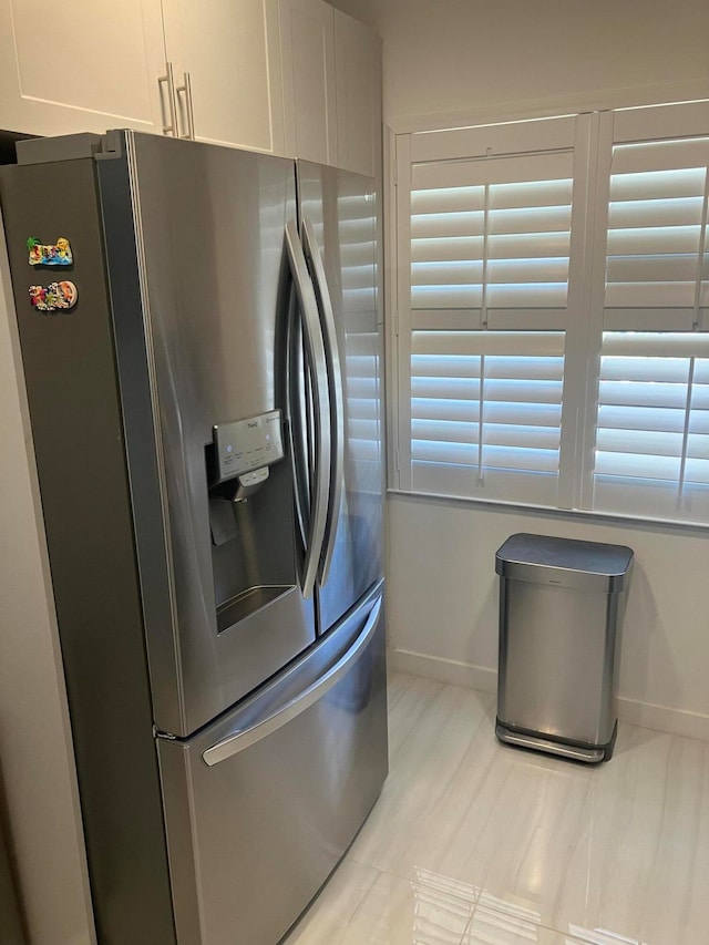 kitchen with white cabinetry and stainless steel fridge