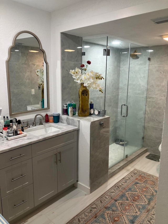 bathroom with vanity, hardwood / wood-style flooring, and walk in shower