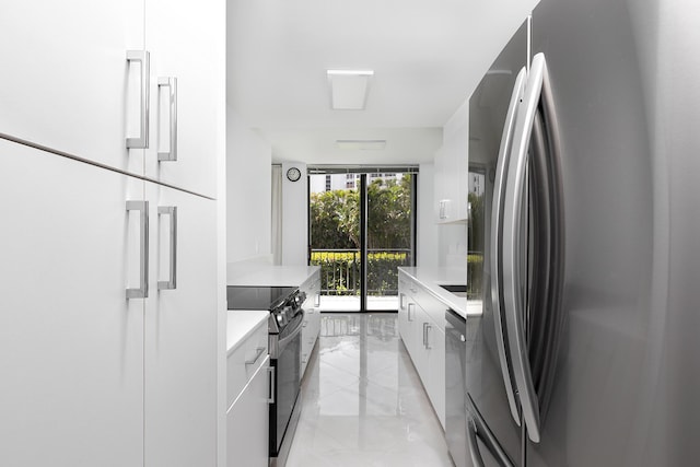 kitchen with floor to ceiling windows, appliances with stainless steel finishes, and white cabinets