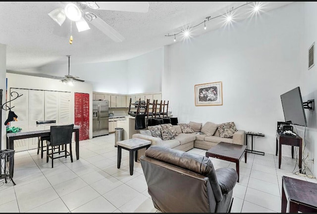 tiled living room with a textured ceiling, high vaulted ceiling, and ceiling fan