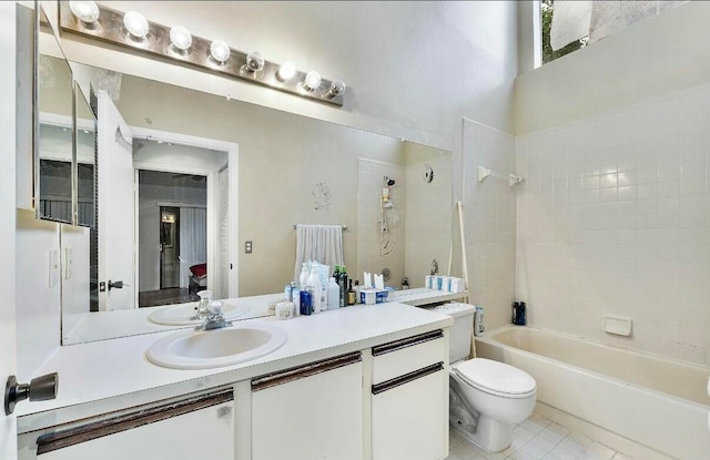 full bathroom with tile patterned flooring, vanity, tiled shower / bath combo, and toilet