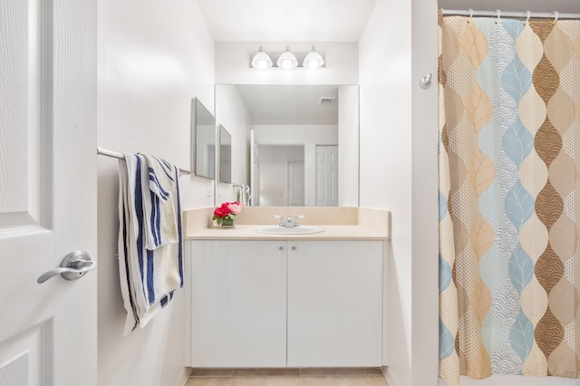 bathroom featuring tile patterned floors, vanity, and walk in shower