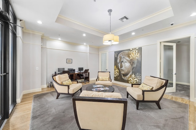 living room with a raised ceiling, french doors, ornamental molding, and light wood-type flooring