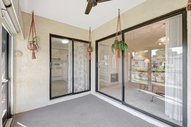 unfurnished sunroom featuring ceiling fan