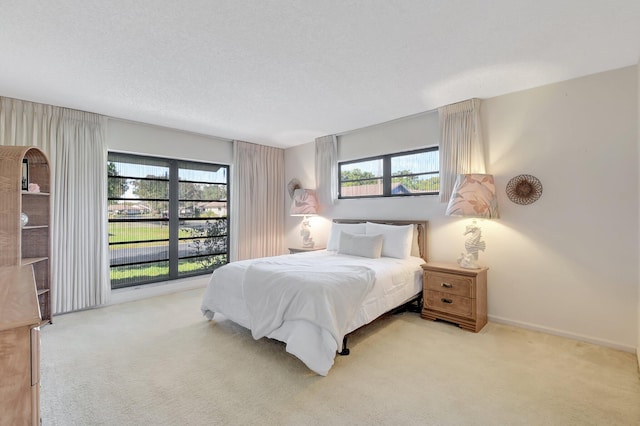 bedroom with carpet floors, multiple windows, and a textured ceiling