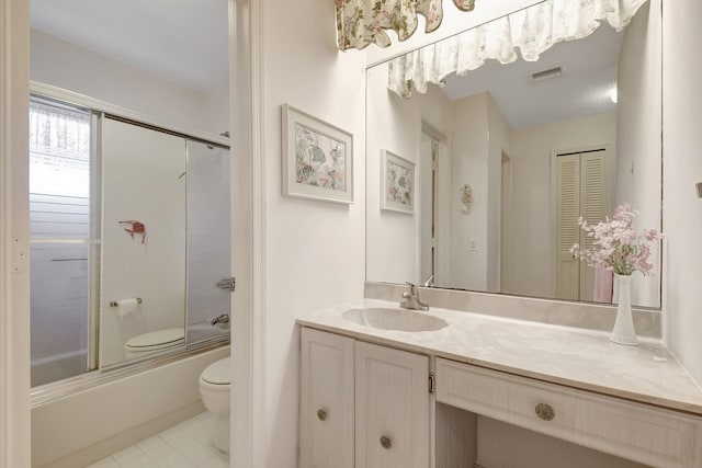 full bathroom with tile patterned flooring, vanity, shower / bath combination with glass door, and toilet