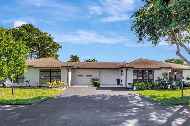 single story home with a front yard and a garage