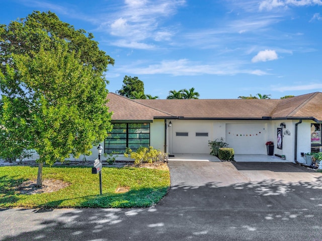 ranch-style house with a garage and a front yard