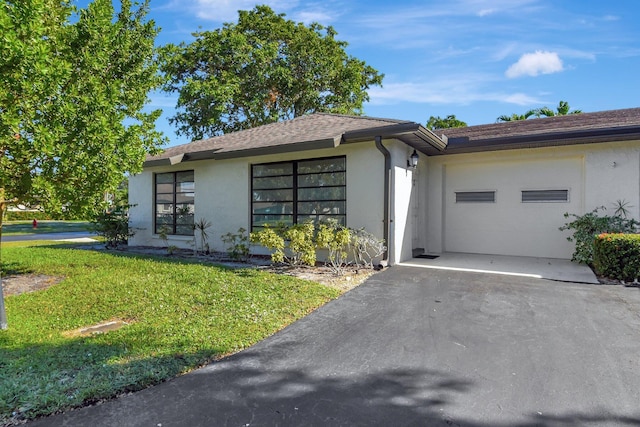 ranch-style house with a garage and a front lawn