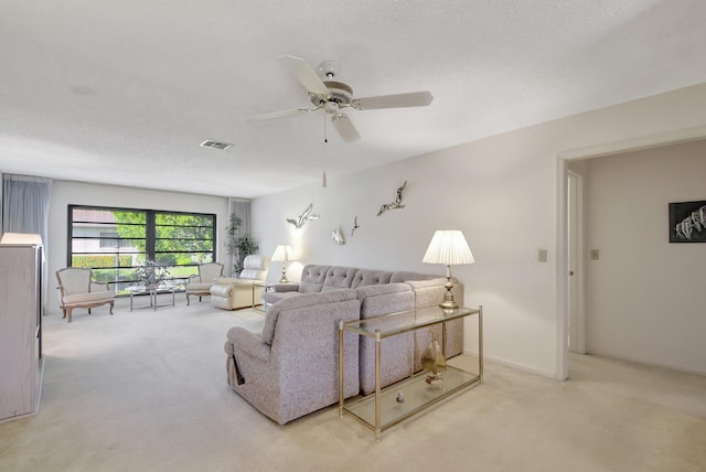 living room with light carpet, a textured ceiling, and ceiling fan