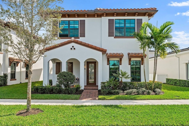 mediterranean / spanish house featuring a front yard