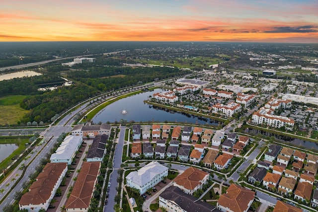 aerial view at dusk featuring a water view