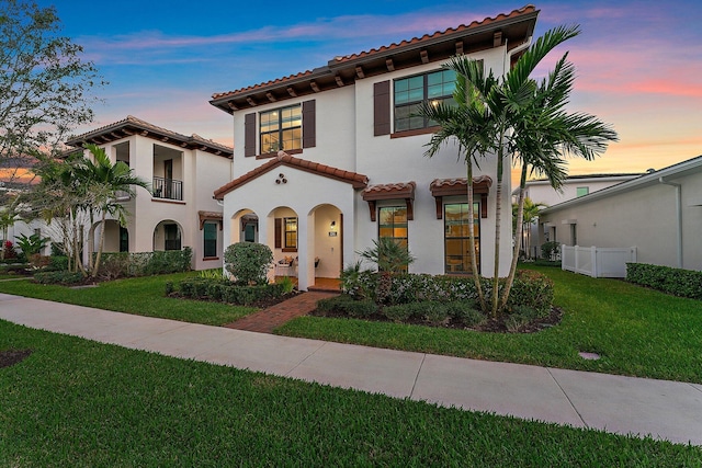 mediterranean / spanish home featuring a yard