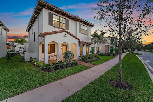 mediterranean / spanish home featuring a lawn