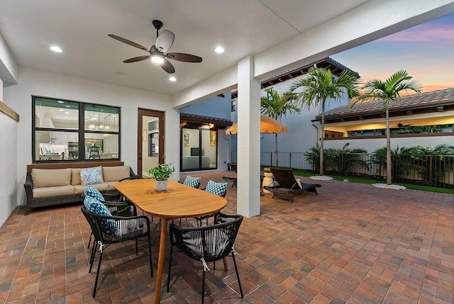 patio terrace at dusk featuring an outdoor hangout area and ceiling fan