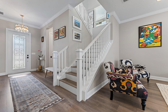 foyer with a chandelier, wood-type flooring, and crown molding