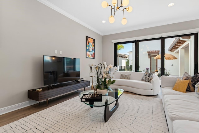 living room with hardwood / wood-style flooring, crown molding, and a chandelier