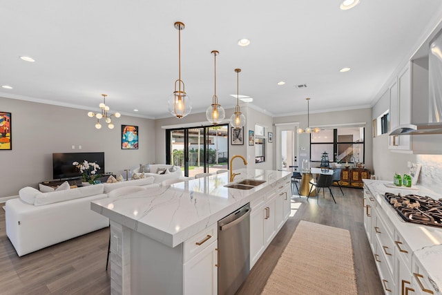 kitchen with appliances with stainless steel finishes, a kitchen island with sink, sink, white cabinets, and dark hardwood / wood-style floors