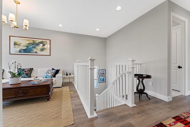 hall with hardwood / wood-style floors and a notable chandelier