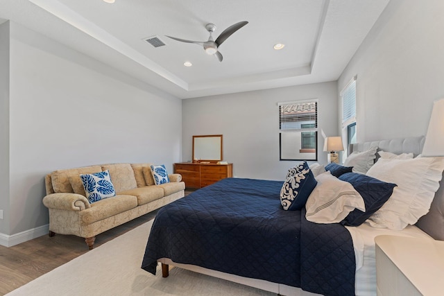 bedroom featuring a tray ceiling, ceiling fan, and hardwood / wood-style flooring