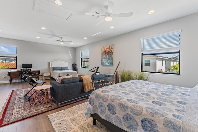 bedroom with multiple windows, ceiling fan, and hardwood / wood-style floors