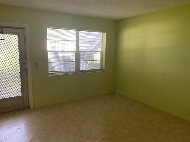 95 Cambridge E Unit 95, West Palm Beach, FL 33417 - tiled empty room featuring baseboards and a textured ceiling