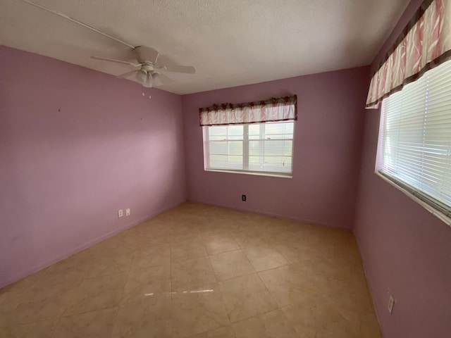 empty room with a textured ceiling and ceiling fan